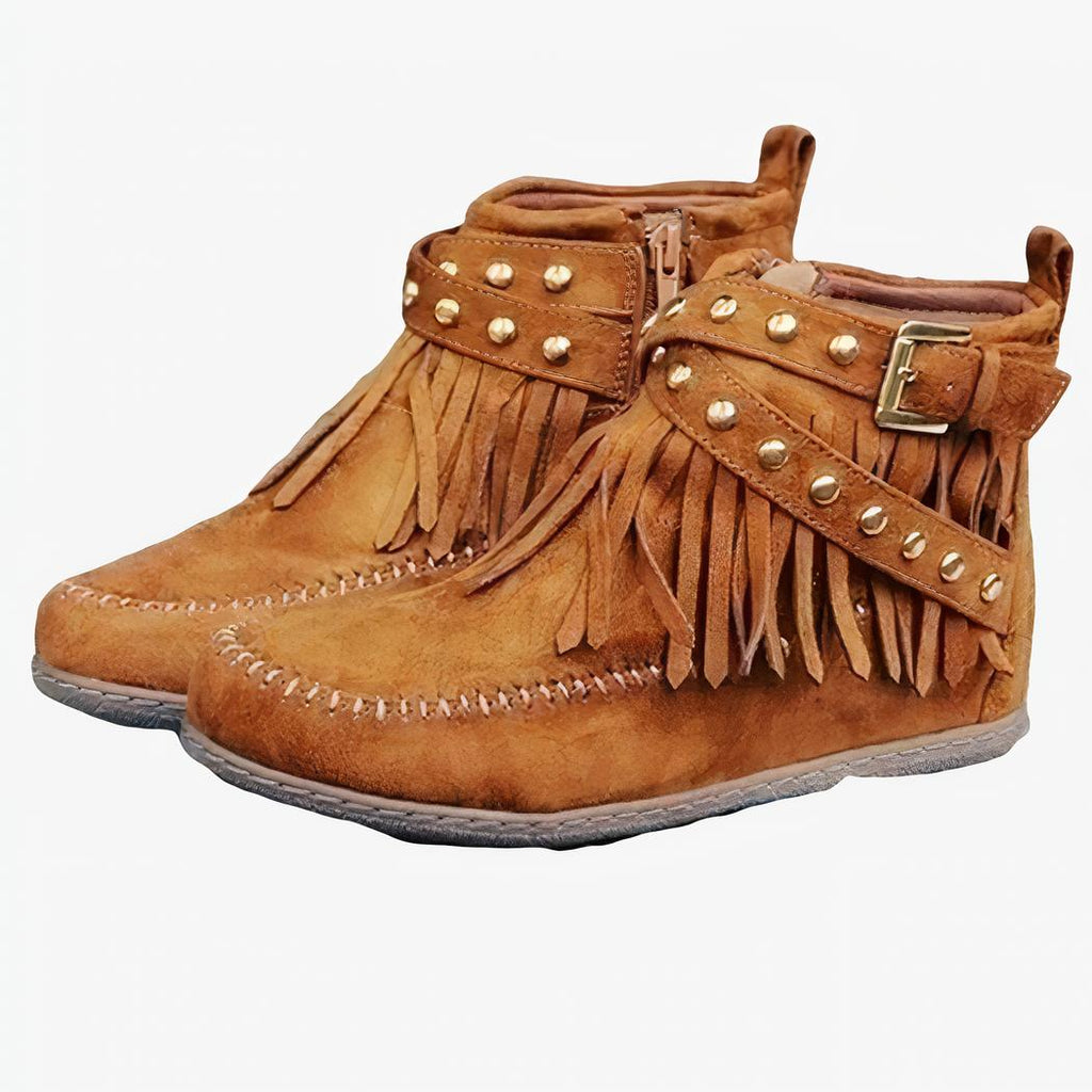 Mocassins indien à franges et boucles en daim de couleur camel posés sur des planches en bois