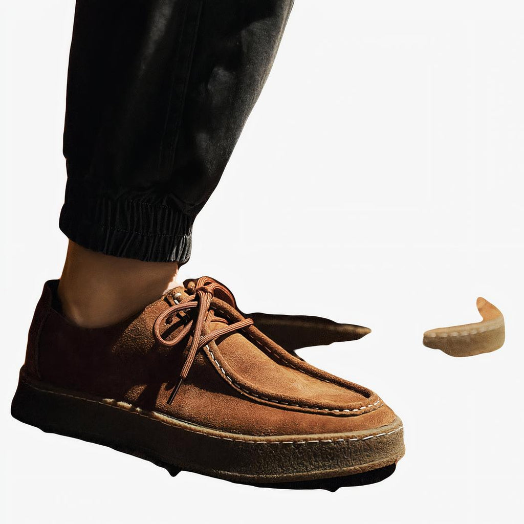 PHoto de mocassin de style indien façon moderne, en daim marron, porté par un homme avec un jean