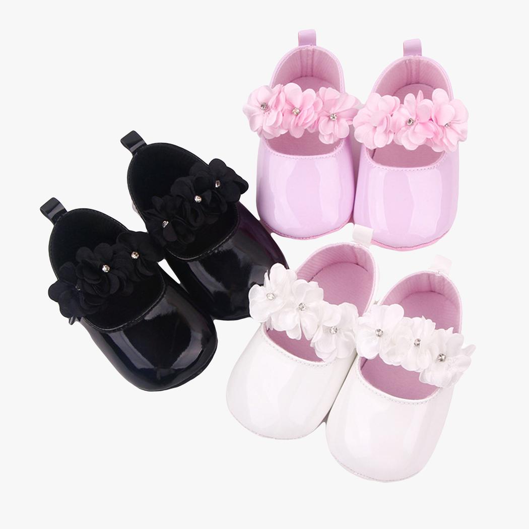 Trois paires de mocassins à fleurs sur fond blanc, de couleur noir, rose et blanc