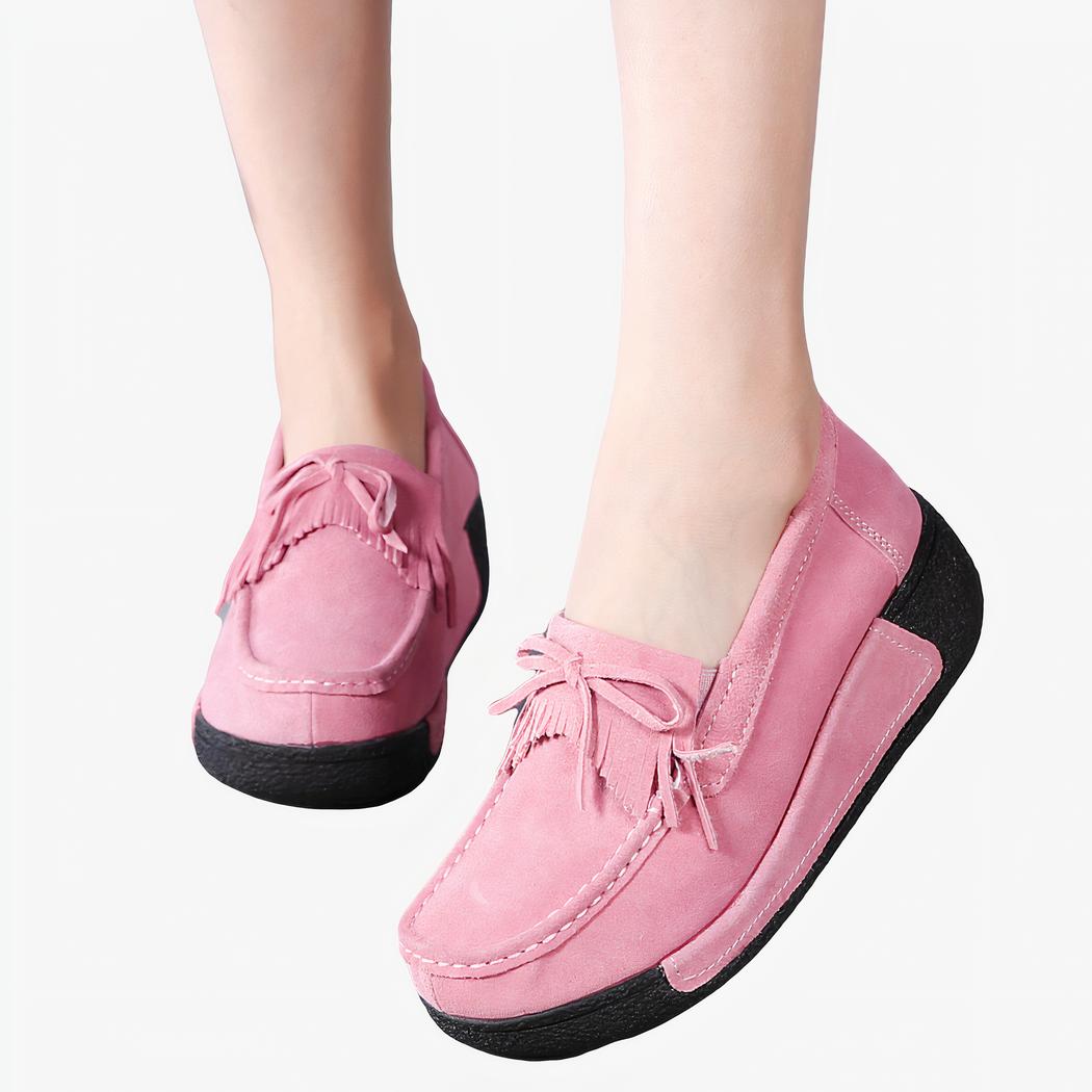 Pieds avec des mocassins roses à franges et noeud sur le devant
