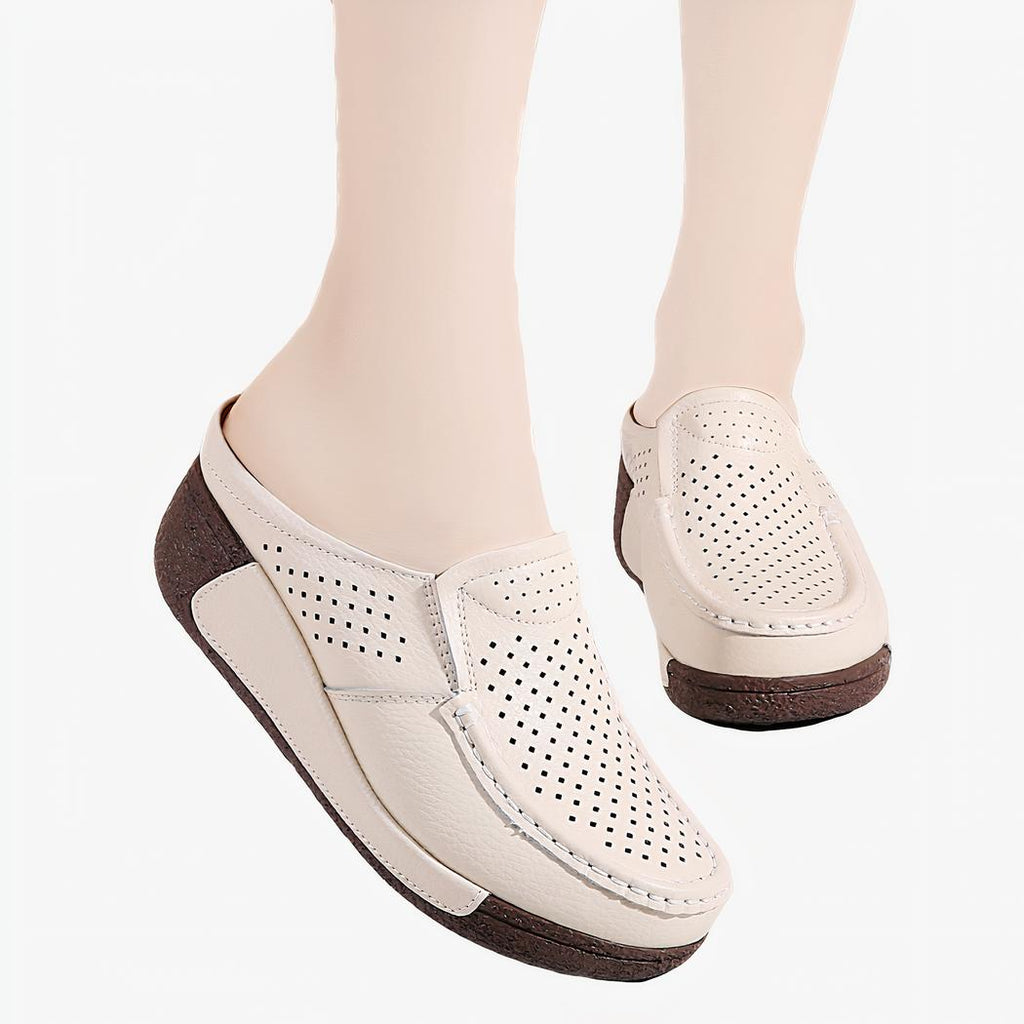 Femme debout portant des mocassins ouverts compensés de couleur beige
