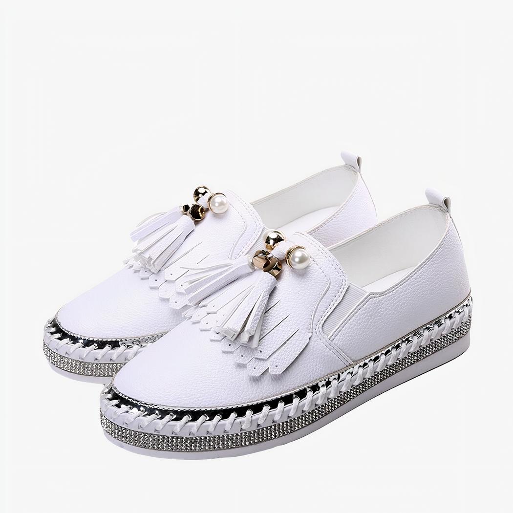 Paire de mocassins blancs à strass et franges sur le devant, sur fond blanc