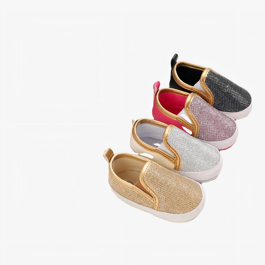 Quatre mocassins doré, argenté, rose et noir alignés en diagonale
