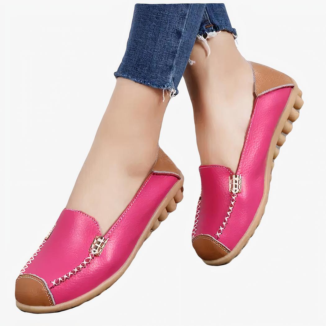 mocassin avec le bout coupé en rose, les pieds posés sur la moquette, la femme ayant les jambes croisées