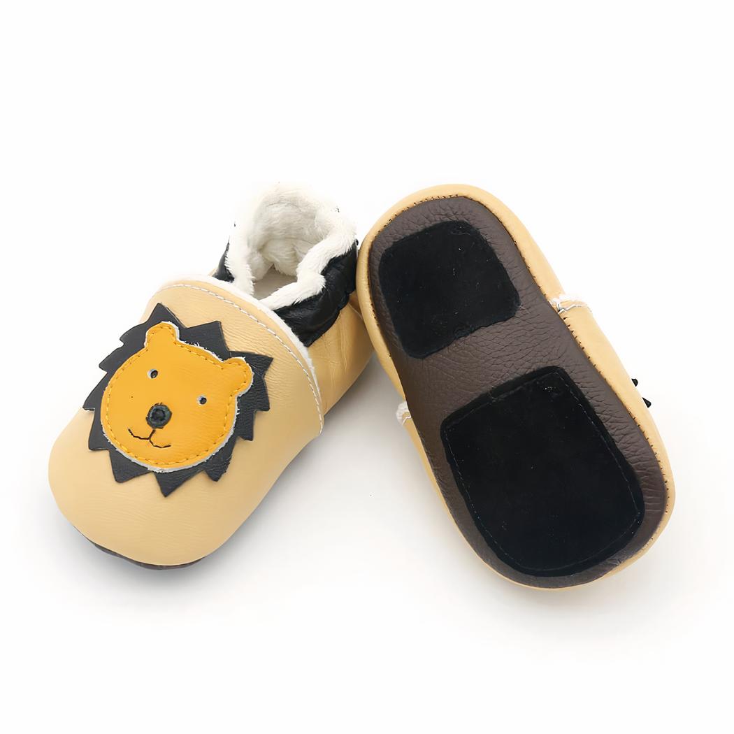 Mocassins souples pour bébé en cuir marron foncé avec tête de girafe jaune. On voit de la peluche douce beige à l'intérieur.