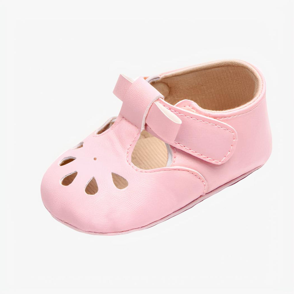 Mocassin rose avec une petite boucle et des petits trous au niveau des orteils sur fond blanc
