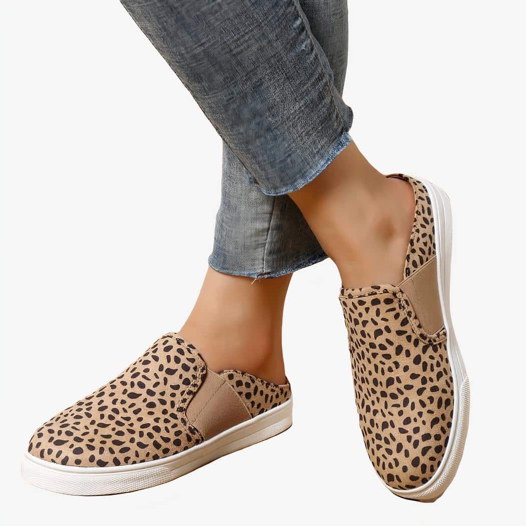 jambes en jean avec chevilles apparentes portant des mocassins beiges imprimé léopard avec plateforme blanche sur un sol en parquet beige.