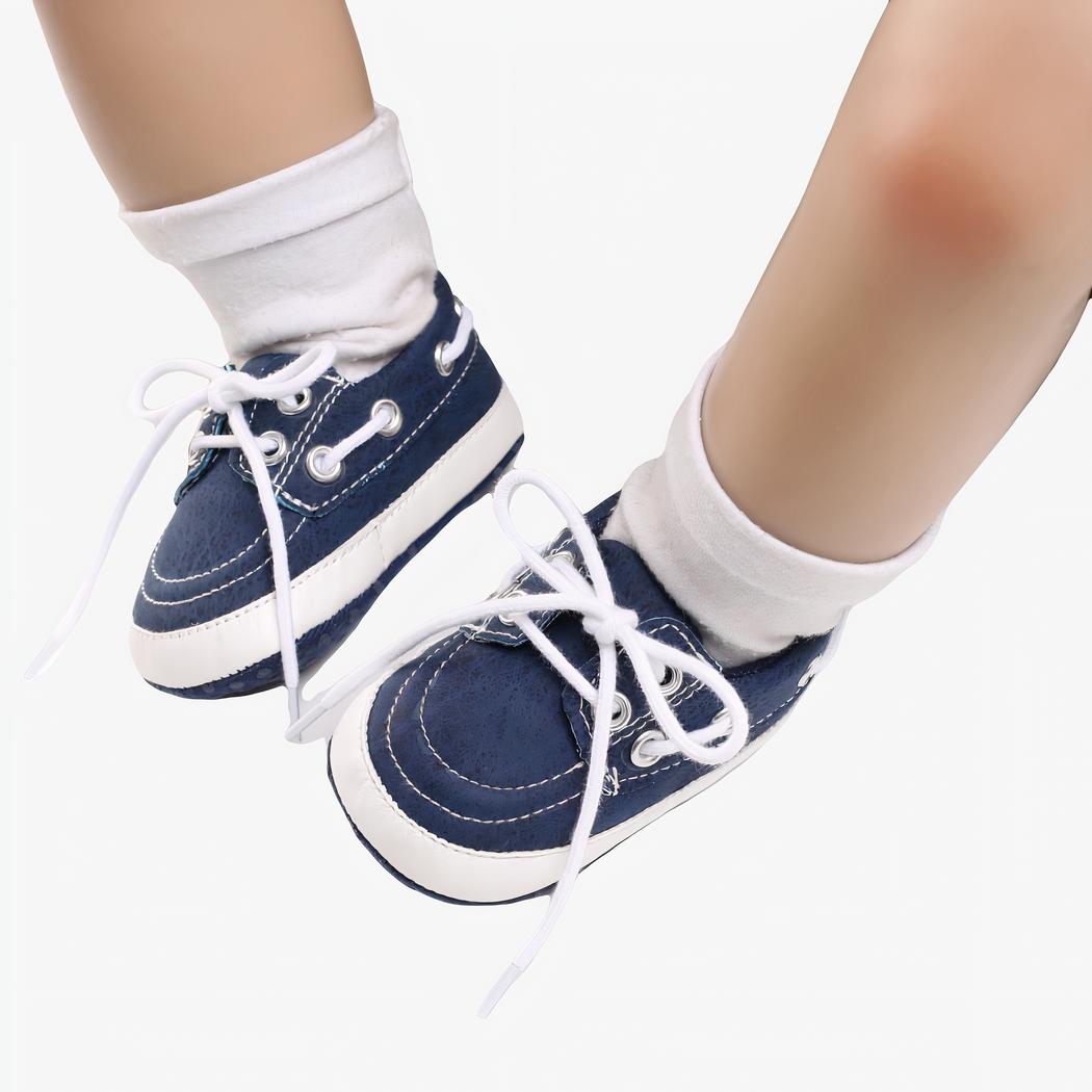Jambes de bébé portant des chaussettes blanches et des mocassins bleus style bateau