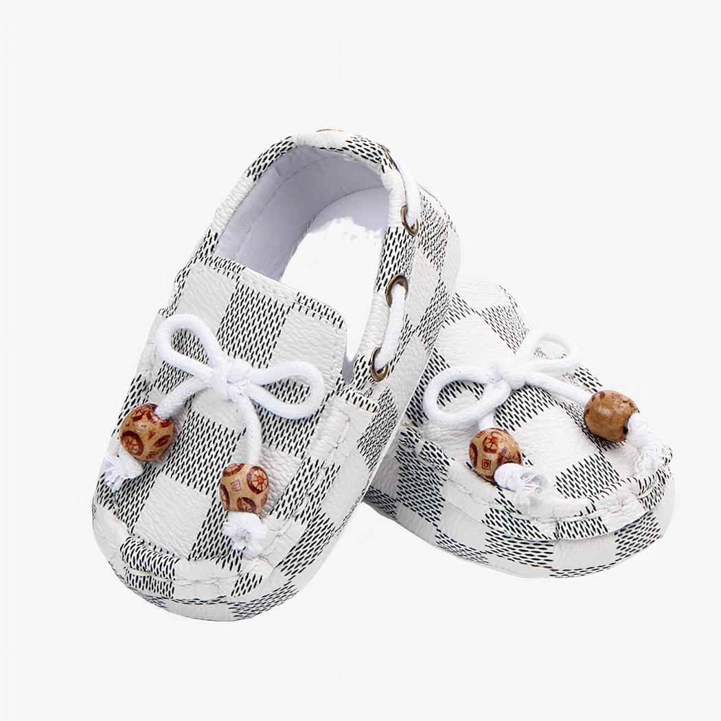 Paire de mocassins à carreaux blancs, avec un lacet et deux perles décoratives