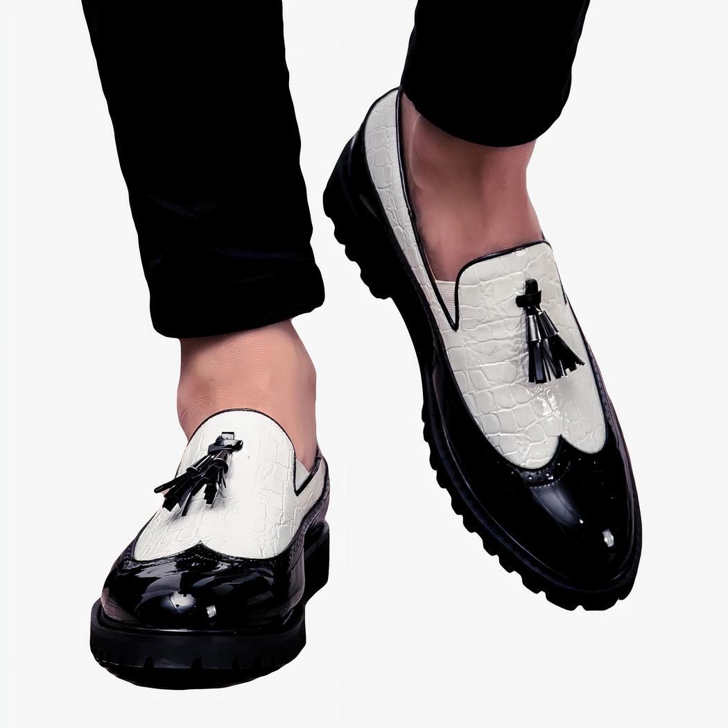 Pieds marchants avec des mocassins noirs et blancs avec un pompon noir sur le dessus.