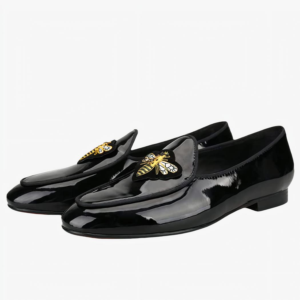 Mocassins brillant avec papillon en or comme boucle sur fond blanc