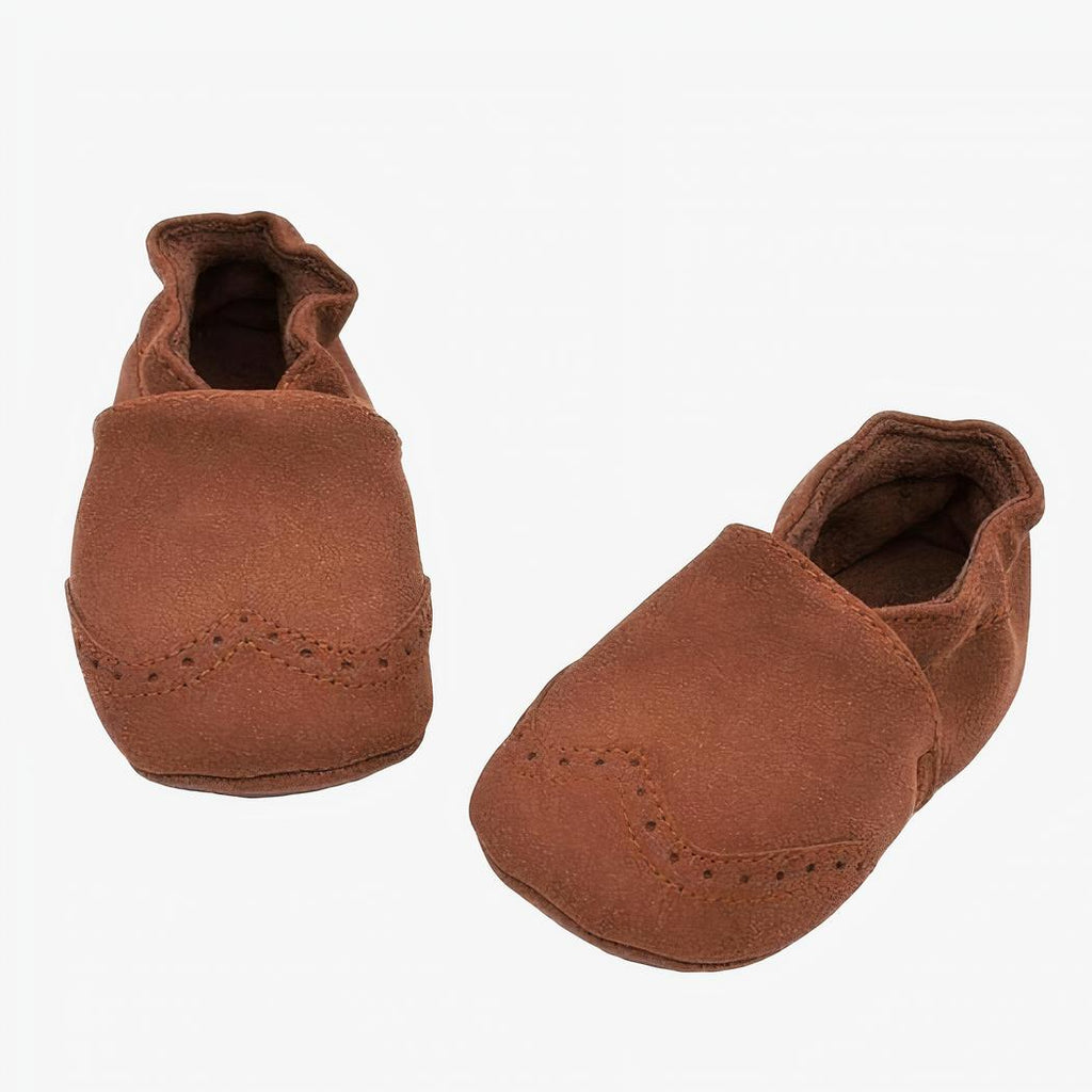Mocassin en faux cuir marron pour bébé poser sur un fond blanc