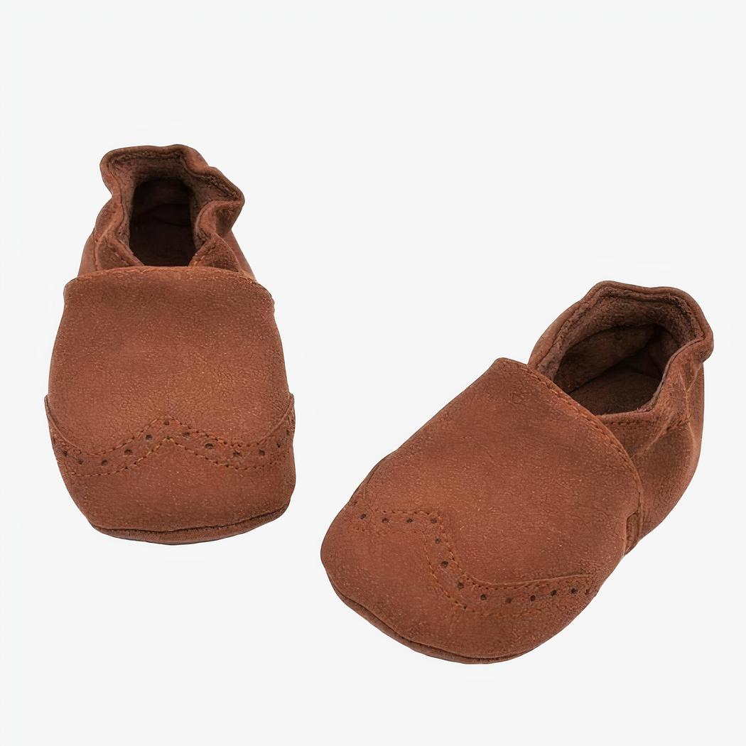 Mocassin en faux cuir marron pour bébé poser sur un fond blanc