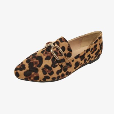 Sur fond clair, un mocassin exposé de profil avec bout carré arrondi en faux velours imprimé léopard et boucles doré métallique sur le dessus. La semelle extérieure est plate et noire.