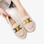 Mocassins en fausse laine avec une chaine pour femmes sur fond gris clair