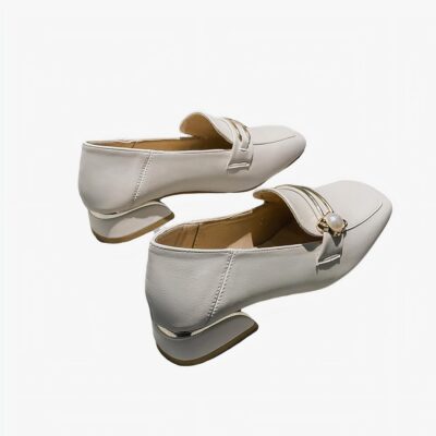 mocassin en PU blanc avec un petit talon poser sur un canapé gris