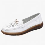 mocassin en cuir blanc avec un gland au dessus poser sur un fond blanc