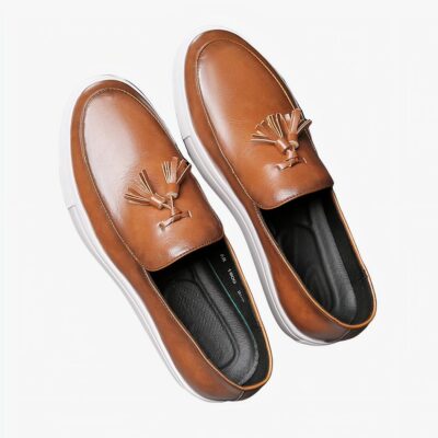 Paire de moccassins marron à gland et semelles épaisse blanche sur un sol gris