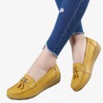 Mocassins jaunes portés par une femme dont on voit seulement les mollets.