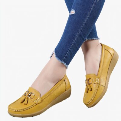 Mocassins jaunes portés par une femme dont on voit seulement les mollets.