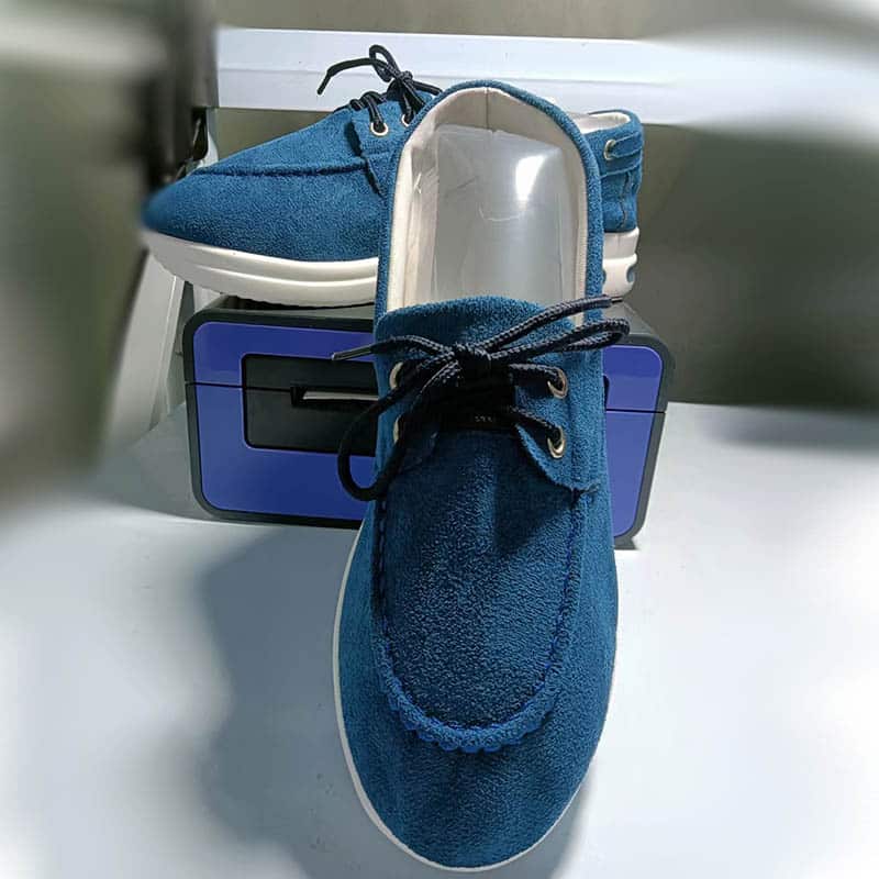 Photo d'une paire de mocassins à plateforme bleue sur un revêtement blanc et posée sur un objet bleu