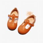 mocassin en faux cuir marron pour petite fille poser sur un journal