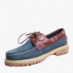 Mocassin bateau bleu et marron sur fond blanc.