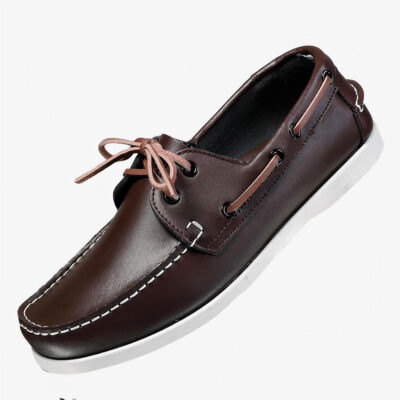 Photo d'un mocassin bateau noir posé sur un meuble blanc avec un fond gris