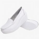 Photo d'une paire de mocassins blanche à semelle compensée sur fond blanc