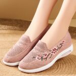 Photo d'une paire de mocassins à plateforme rose portée par une femme sur un sol beige