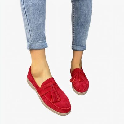 Femme qui porte les mocassin en cuir rouge avec un gland