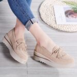 mocassin compensé à gland beige porté par une femme