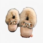 mocassin à fourrure avec un anneaux pour bébé porter dans la main d'une femme