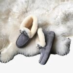 Mocassin indien d'hiver en daim gris fourrés posés sur un tapis en fourrure