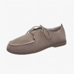 Mocassin beige en daim à lacets avec l'intérieur en moumoute sur un fond blanc