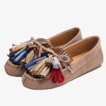 mocassin en faux daim marron avec un gland au dessus poser sur un fond blanc