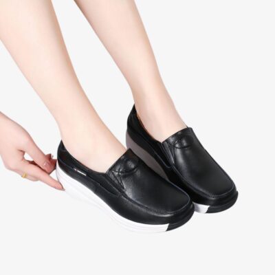 Paire de pieds avec des chaussures noires à semelle blanche