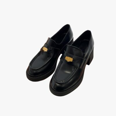 Mocassins noirs sur un boite de chaussure marron