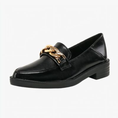 Mocassin en cuir noir verni synthétique avec chaîne dorée décorative sur un fond blanc