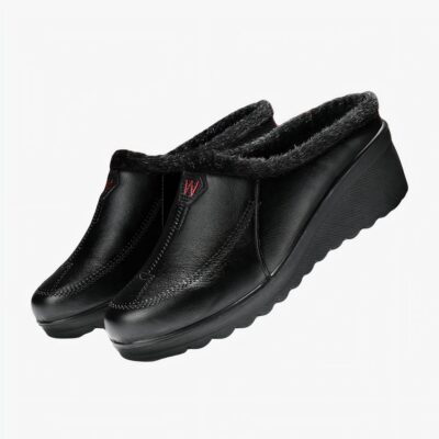 demi mocassin en faux cuir noir poser sur des libres.