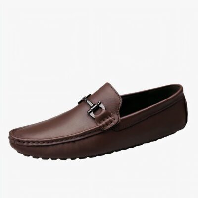 Mocassin marron en cuir avec gland en forme de mors à cheval couleur or sur un fond blanc