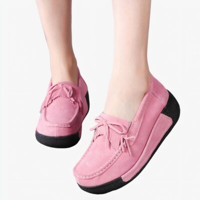 Pieds avec des mocassins roses à franges et noeud sur le devant
