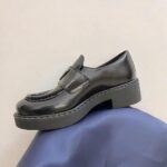mocassin en cuir noir poser sur un sol bleu
