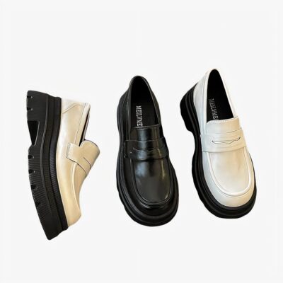Sur moquette grise 3 mocassins posée blancs et noirs ils brillent