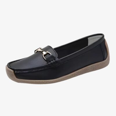 Mocassins en cuir réhaussés de détails dorés pour femme de couleur noir sur fond gris clair.
