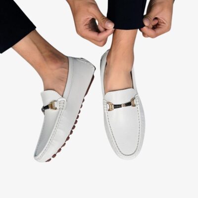 Paire de mocassins blancs en cuir pour homme, portées par un homme avec un pantalon noir