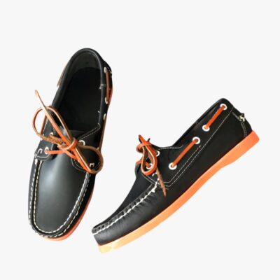 Mocassins bateau aspect cuir à semelle colorée pour homme sur fond gris clair.