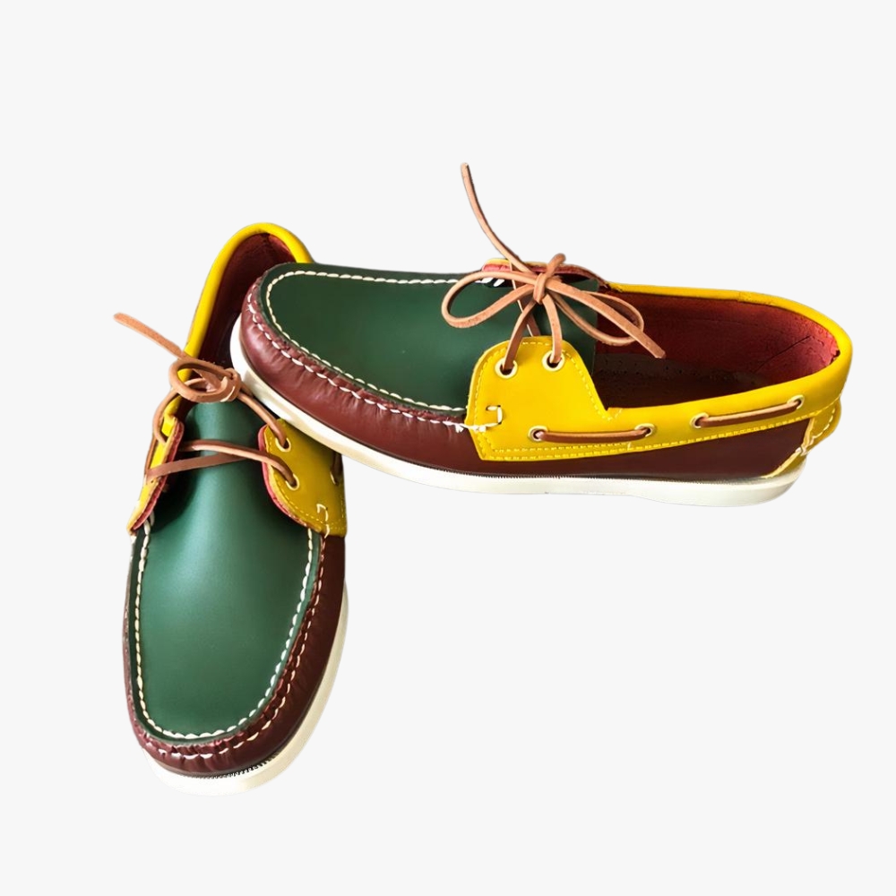 Mocassins bateau tricolores à lacets avec aspect cuir pour homme sur fond gris clair.