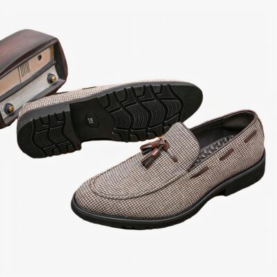 Deux mocassins gris posé sur du parquet à gland marron
