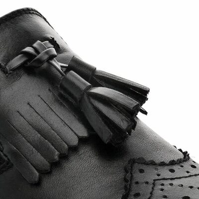 Paire de mocassins noirs à glands sur fond blanc